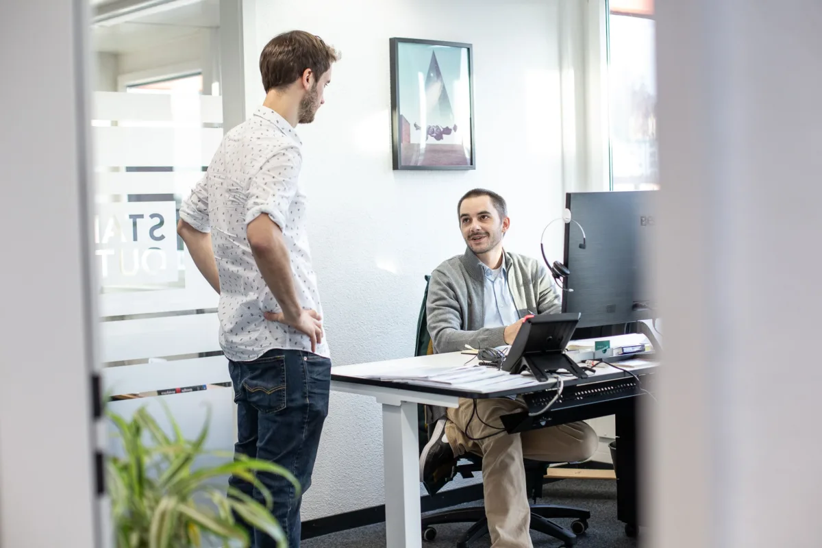 Mitarbeitende der Standout GmbH im Austausch zu digitalen Strategien in moderner Büroumgebung